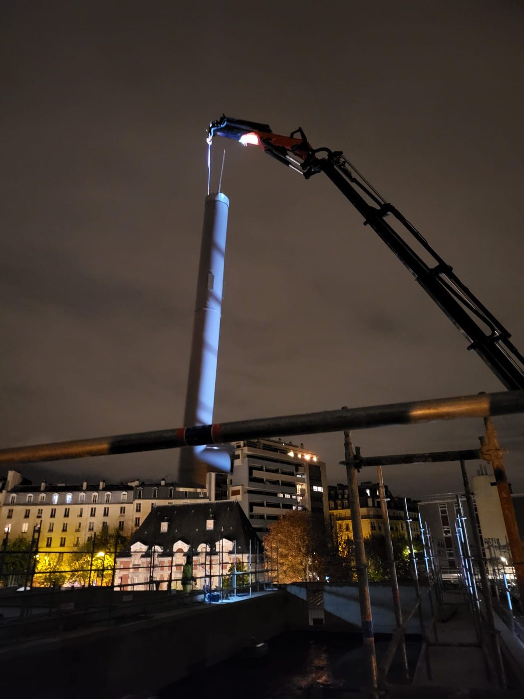 Levage de matériel en pleine nuit en zone urbaine.